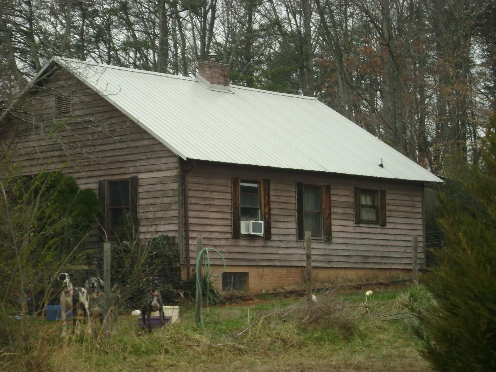 White metal roof on an old wood sided farmhouse, from a Metal Roof Installation job in Llano